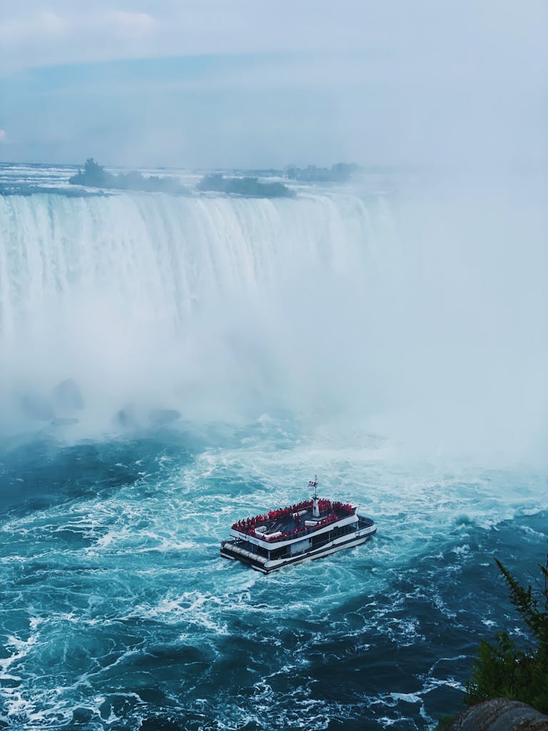 Boat Sailing under Waterfall